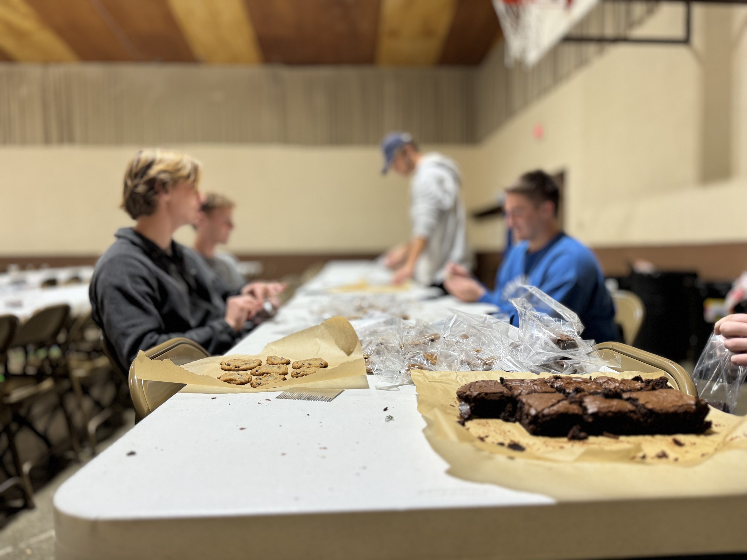 Volunteers preparing baked goods for a bake sale to support the mission.